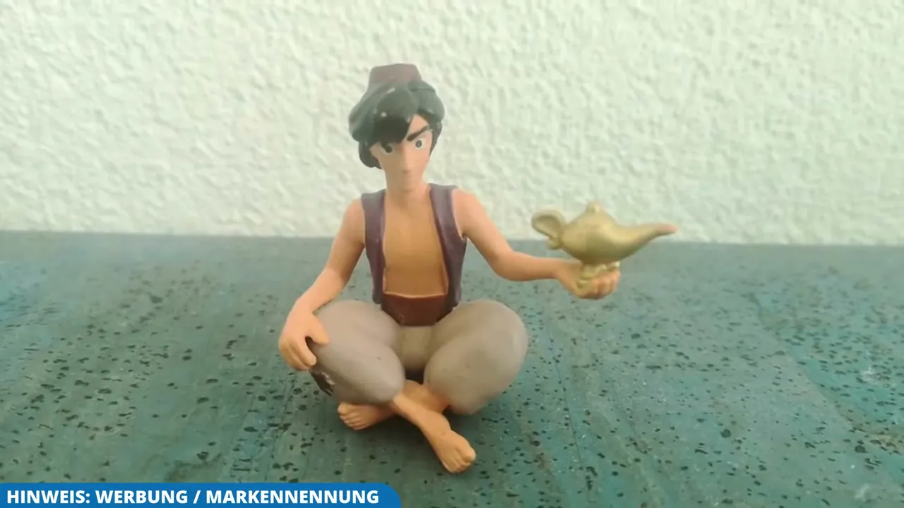 Die Toniefigur zeigt Aladdin im Schneidersitz mit der goldenen Wunderlampe in der Hand.