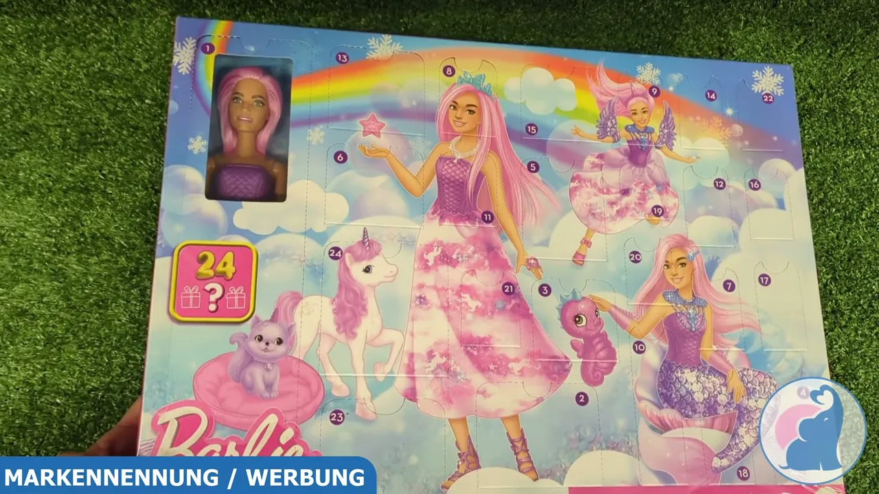 Auf der Vorderseite des Kalenders ist durch das Sichtfenster bereits die Barbie-Puppe mit langen, rosa Haaren zu erkennen.