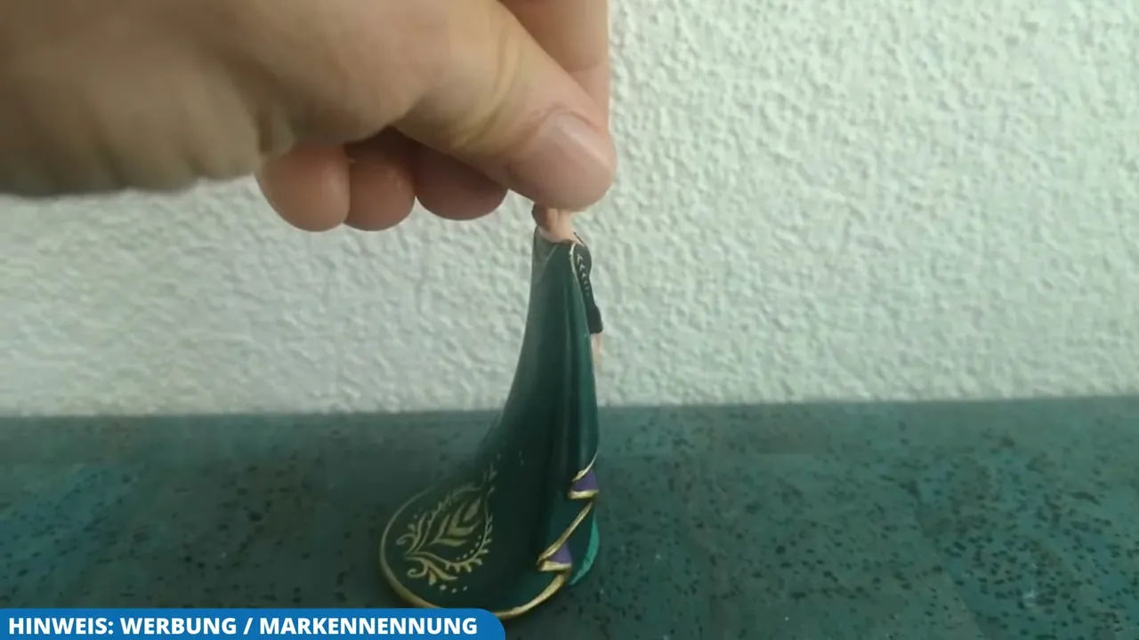 Auf der Rückseite des Umhangs sind die feinen Verzierungen der handbemalten Spielfigur gut zu erkennen.