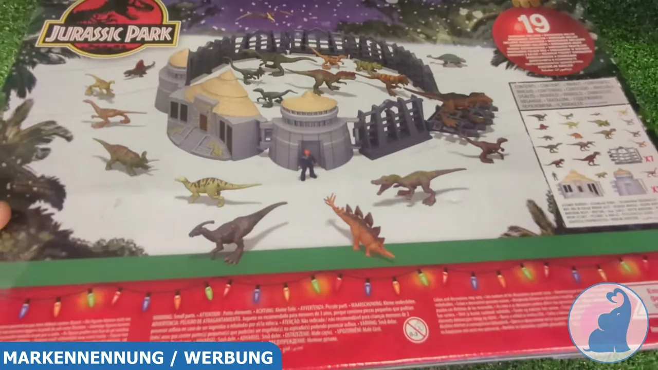 Auf der Rückseite ist das aufgebaute Spielset mit dem Besucherzentrum, Zaunelementen und den Minifiguren abgebildet.