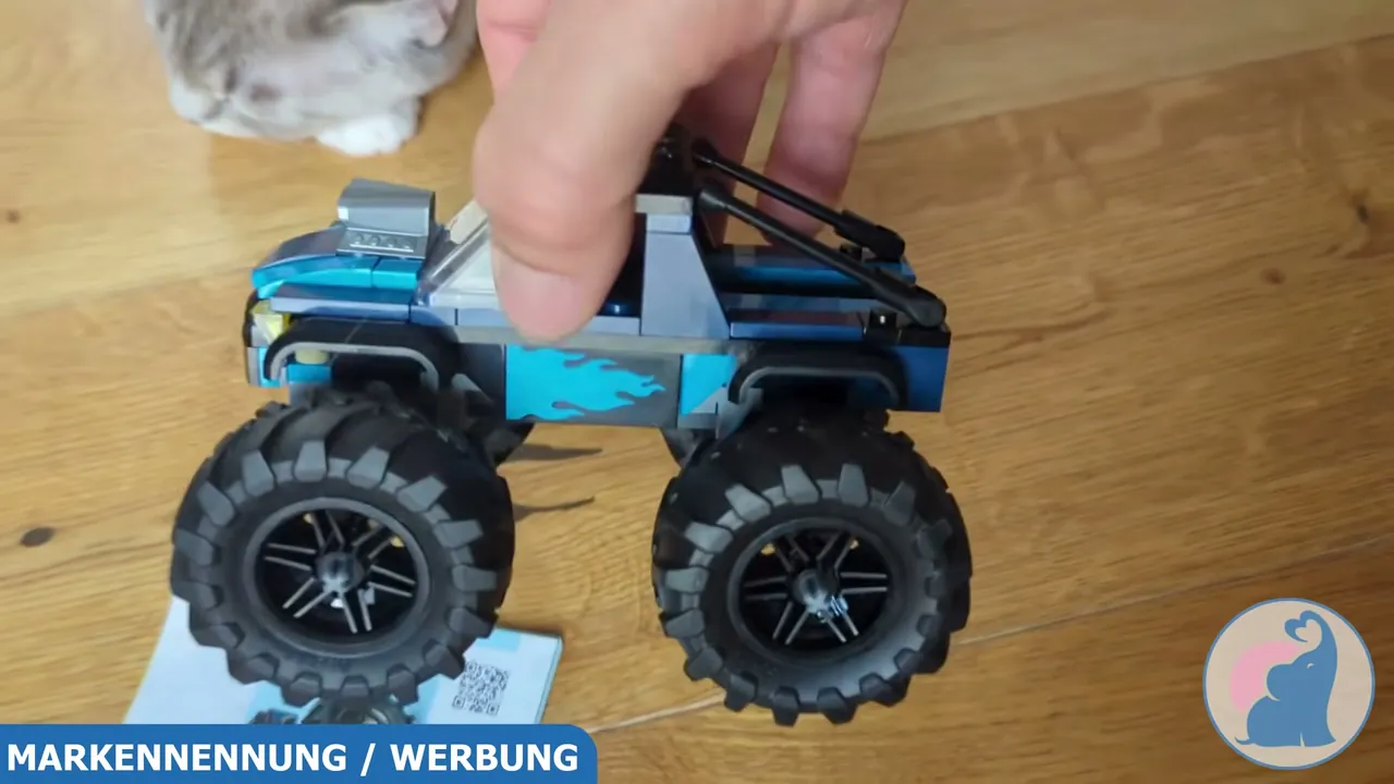 Die Seitenansicht zeigt das kompakte Design mit Flammen-Dekor sowie die hohe Bodenfreiheit des Offroaders.