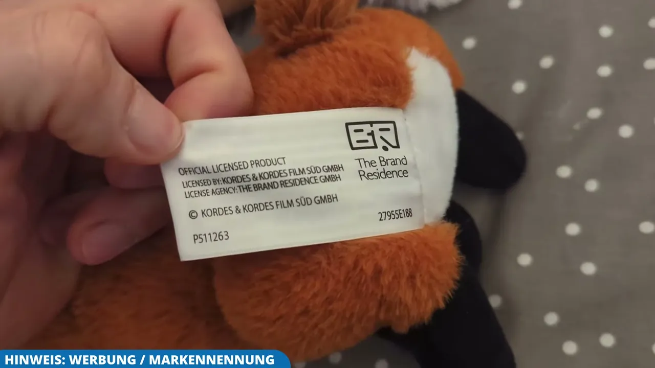 Ein eingenähtes Textiletikett weist das Stofftier als offizielles Lizenzprodukt der Reihe aus.